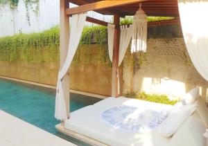 a bed with a canopy in a room with water at Villa Savasana - Rooftop Ocean Sunsets in Canggu