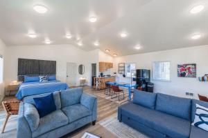 奥福德港#StayinMyDistrict Oceanview Studio Loft的一间卧室配有一张床和两张蓝色的沙发 更多70张照片