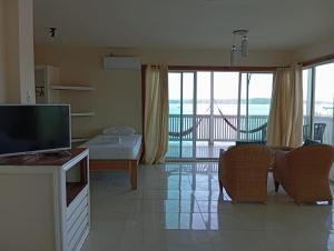 a living room with a flat screen tv and a living room at Los Balcones Over The Sea in Carenero