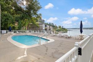 a swimming pool on a patio next to the water at Emerald Bay Unit 1B in Lake Ozark