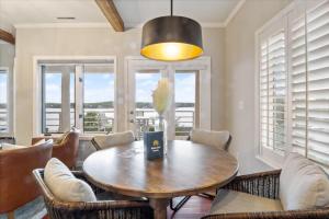 a dining room with a table and chairs and windows at Emerald Bay Unit 1B in Lake Ozark