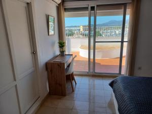 een slaapkamer met een bureau en uitzicht op een balkon bij Ático en Estepona, Malaga in Estepona