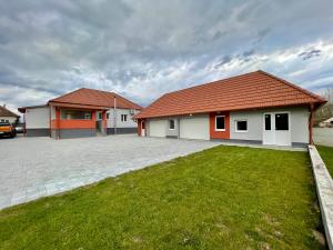 a house with a green lawn in front of it at K71 Guest House in Fertőd