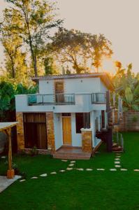 a small white house with a porch and a yard at Tiny house with amazing view in Arusha