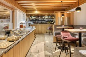 a restaurant with a counter with bar stools at Hotel Bellevue in Tirolo