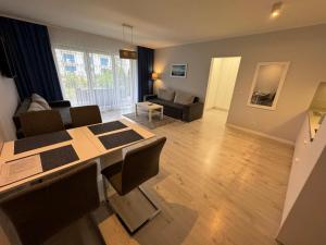 a living room with a table and chairs and a couch at Apartment Bursztyn z ogródkiem I 250m od plażey - Apartment Bernstein mit Garten I 250m vom Strand in Pogorzelica