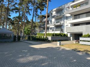 a parking lot in front of a building at Apartment Bursztyn z ogródkiem I 250m od plażey - Apartment Bernstein mit Garten I 250m vom Strand in Pogorzelica
