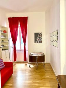 sala de estar con sofá rojo y mesa en la casa di Romolo, en Roma