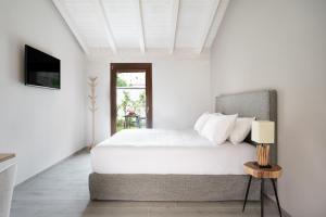 a white bedroom with a bed and a television at Villa Il Platano in Como