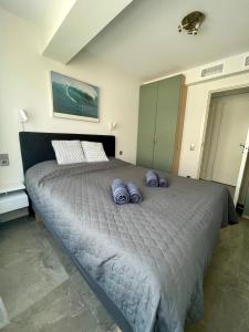 a bedroom with a large bed with purple pillows on it at Sea Side apartments in Santa Pola