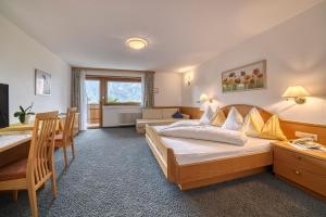 a hotel room with a bed and a table and a desk at Hotel Bellevue in Tirolo
