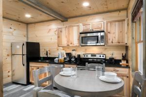 a kitchen with a table with chairs and a refrigerator at Bear Necessity by Stony Brook Cabins in Gatlinburg