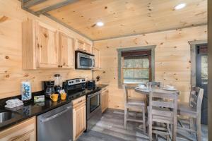 a kitchen with a table and chairs in a cabin at Bear Necessity by Stony Brook Cabins in Gatlinburg