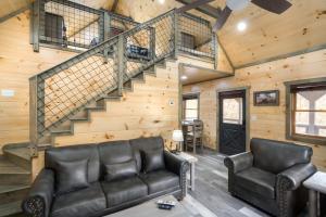 a living room with a couch and a staircase at Bear Necessity by Stony Brook Cabins in Gatlinburg