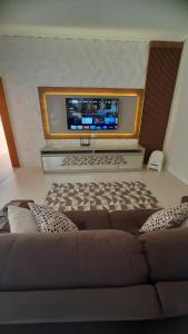 ein Wohnzimmer mit einem Sofa und einem Flachbild-TV in der Unterkunft HillTop Serra da Mantiqueira in Sapucaí-Mirim