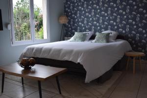 a bedroom with a large bed with a window at L'Aquarelle - Appartement cosy, GroupamaStadium LDLC Arena in Meyzieu +13 photos