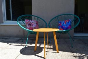 two green chairs and a table with bags on them at L'Aquarelle - Appartement cosy, GroupamaStadium LDLC Arena in Meyzieu