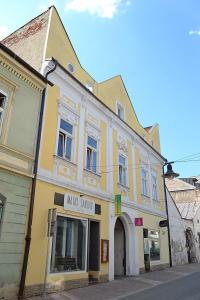 un edificio amarillo al lado de una calle en SPAYA JACUZZI centrum apartment - with home cinema & private parking en Košice