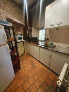 une cuisine avec des armoires blanches et un sol carrelé dans l'établissement Maison indépendante au cœur de la beauce, à Terminiers