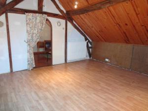 une chambre mansardée avec un plancher et des plafonds en bois dans l'établissement Maison indépendante au cœur de la beauce, à Terminiers