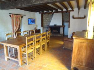 une salle à manger avec une table et des chaises et une cheminée dans l'établissement Maison indépendante au cœur de la beauce, à Terminiers