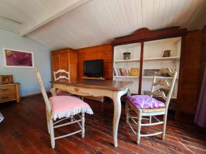 um quarto com uma mesa de madeira e 2 cadeiras em Casa del Paso em Bolulla