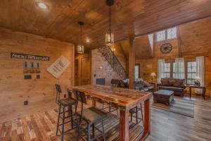 a log cabin with a large wooden table and chairs at Black Bear Cabin by Stony Brook Cabins in Gatlinburg