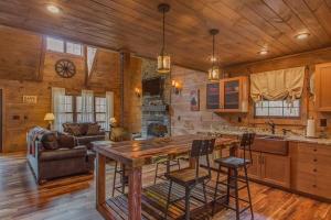 a kitchen and living room with a table in a cabin at Black Bear Cabin by Stony Brook Cabins in Gatlinburg