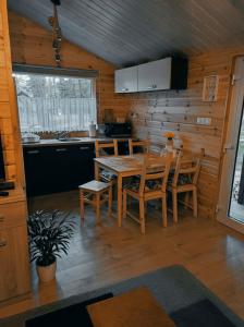 a kitchen and dining room with a table and chairs at Domek pod sosnami in Grodziczno +8 photos