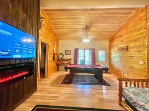 a living room with a pool table and a tv at Dancing Bear in Sevierville