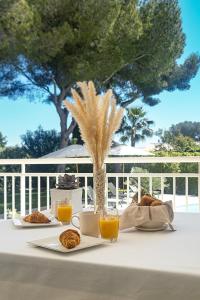 - une table avec de la nourriture et deux verres de jus d'orange dans l'établissement LA VILLA ALBA, aux Issambres