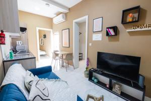 a living room with a blue couch and a flat screen tv at Happiness in Qormi