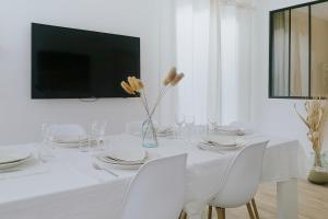 una mesa blanca con sillas blancas y un jarrón con flores en LA VILLA ALBA, en Les Issambres
