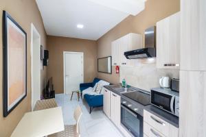 een kleine keuken met een blauwe bank in een kamer bij Happiness in Qormi