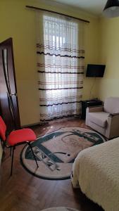 een woonkamer met een bed en een rode stoel bij 1ком апартаменты,парковка,улХорватская in Lviv