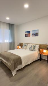 um quarto com uma grande cama branca e 2 candeeiros em Cristal House 250 meters from Monte Gordo beach em Monte Gordo