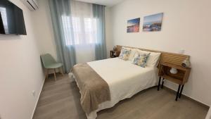 a bedroom with a bed in a room with a window at Cristal House 250 meters from Monte Gordo beach in Monte Gordo