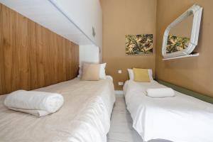 two beds in a small room with a window at Happiness in Qormi