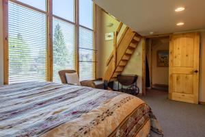 a bedroom with a large bed and a staircase at Alpine Villa Condo 1 in Ketchum