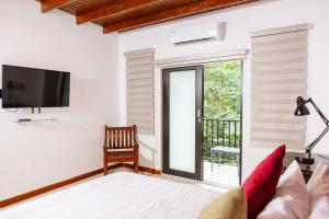 um quarto com uma televisão, uma cama e uma varanda em Casa Campo Bed & Breakfast em San Sebastian