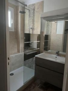 a bathroom with a shower and a sink and a mirror at Bas de villa avec grande piscine in Marseille