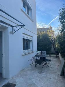 a patio with a table and chairs next to a building at Bas de villa avec grande piscine in Marseille