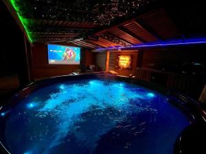a large blue tub in a room with a tv at Between Rivers Camping @ The Old George Inn in Sykehouse