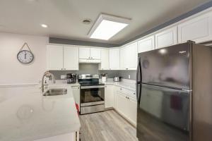 eine Küche mit weißen Schränken und einem Edelstahlkühlschrank in der Unterkunft Lake of the Ozarks Vacation Rental Boat DockandSlip in Lake Ozark