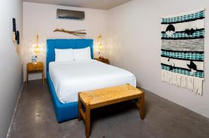 a bedroom with a bed with a blue chair and a table at Parguera Plaza Hotel - Adults Only in La Parguera