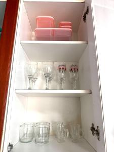 a cupboard filled with lots of wine glasses at Fique no Centro de Petrolina in Petrolina