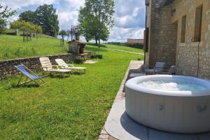 a large bath tub sitting outside of a house at With the family -A peaceful stay in the countryside- spa 8-10 pers in Gaugeac