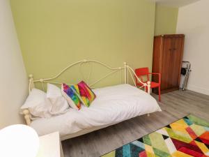 une chambre avec un lit et une chaise rouge dans l'établissement The Old Factory House, à Berwick-upon-Tweed