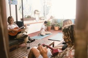 un grupo de personas sentadas en una habitación tocando la guitarra en Agüita House en Las Palmas de Gran Canaria