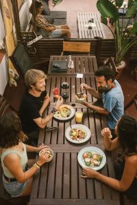 un grupo de personas sentadas alrededor de una mesa comiendo comida en Agüita House, en Las Palmas de Gran Canaria